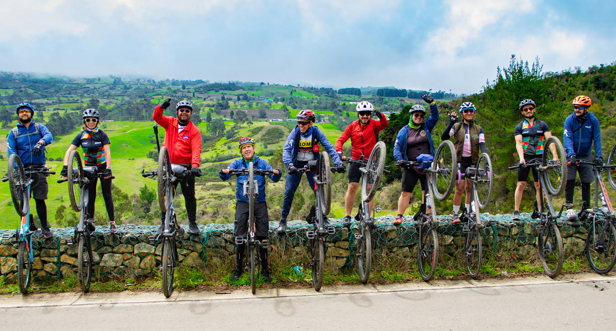 Estos ciclistas hacen una parada en el recorrido, y celebran, con los paisajes de la región como telón de fondo. Foto: Santiago Rincón - IDT