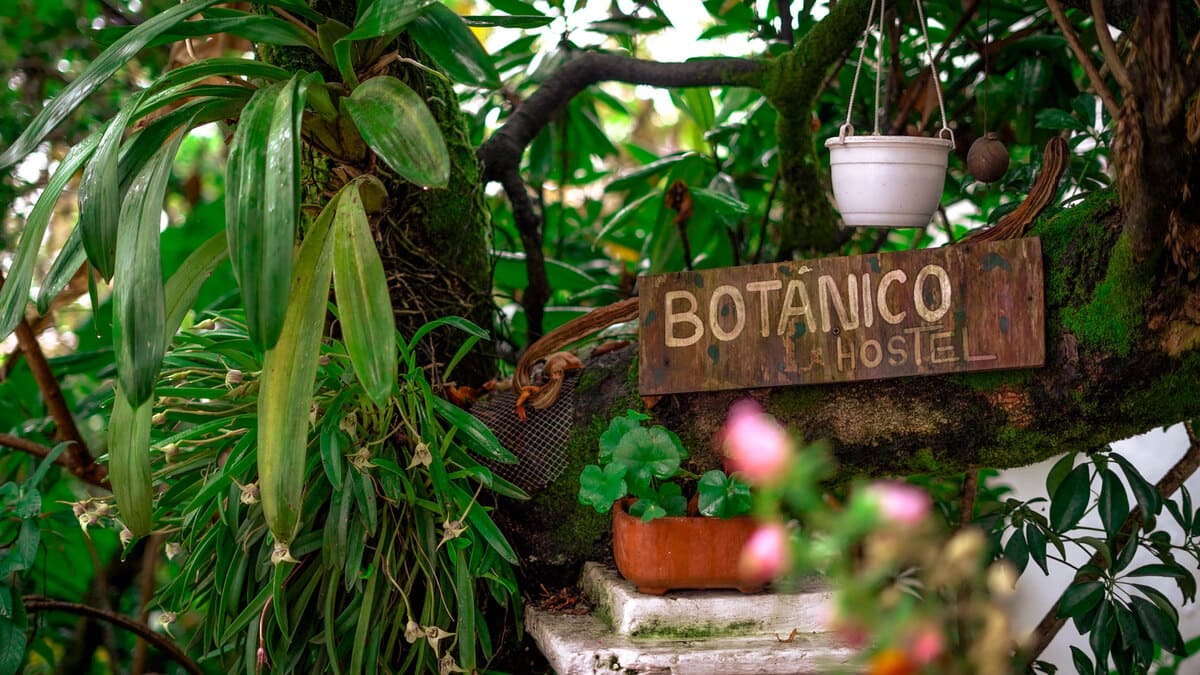 The welcome is given by a wooden sign with the name of the hostel, surrounded by plants. Photo by Manuela Picón - IDT