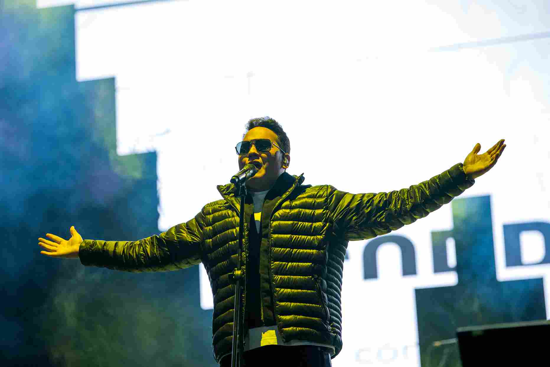 Un artista se presenta con los brazos abiertos durante el festival Gospel al Parque. El juego de luces y la puesta en escena reflejan la fuerza de este género que conecta a miles de asistentes. Foto: Archivo IDRD