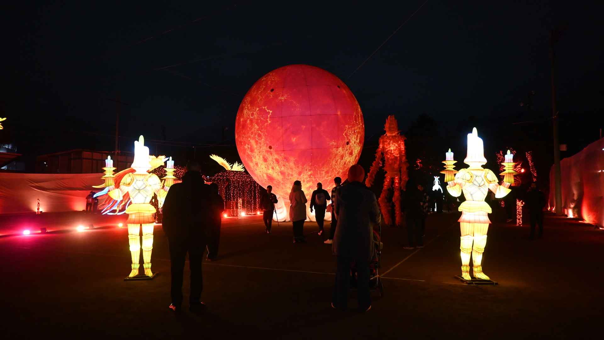 Paisaje nocturno fantástico con luna roja y figuras iluminadas en Festival Brilla 2024. Foto: Érika Gutiérrez - Archivo IDT.